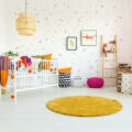 babykamer decoratie idee met kleedje en pastelkleuren